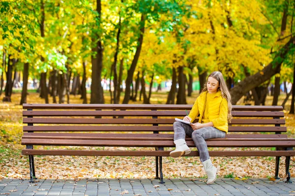 Młoda Piękna Dziewczyna Rysuje Ołówkiem Szkicowniku Siedząc Jesiennym Parku — Zdjęcie stockowe