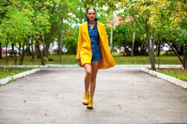 Sarı ceketli şık bir mankenin portresi. 