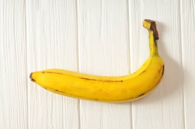 Olgun sarı muz withn siyah noktalar Beyaz ahşap zemin üzerinde