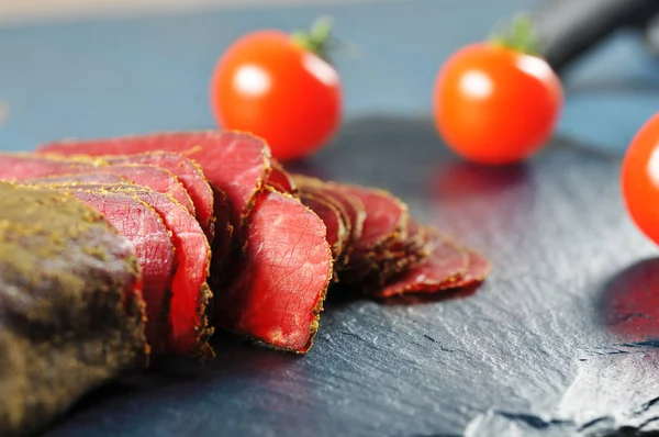 Φέτες Παστό Κρέας Και Κόκκινες Ώριμες Ντομάτες Σκούρο Μπλε Κοπής — Φωτογραφία Αρχείου