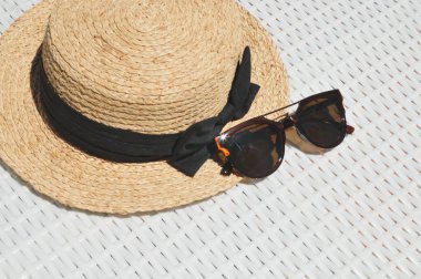 Hasır şapka ve güneş gözlüğü beyaz arka planda siyah yayla