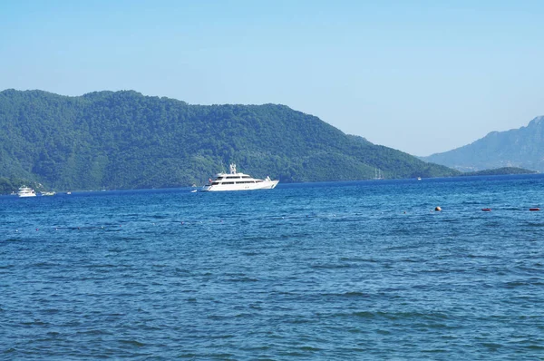 Tekneler ve yatlar denizde dağlar ve mavi gökyüzü ile