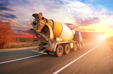 Mavi beton mikseri kamyonu ağaçlar gökyüzü günbatımı ile karşı ile kırsal yolda