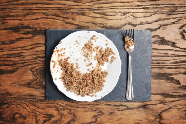 Weißer Keramikteller Mit Buchweizen Und Silbergabel Auf Dunkelblauem Brett Und — Stockfoto