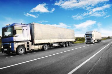 Büyük kamyon ve mavi gökyüzü bulutlu karşı kırsal yolda metin için yer ile beyaz römork