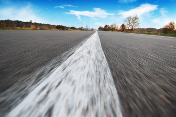 Close-up van een verkeers lijn op een lege weg in beweging met een — Stockfoto