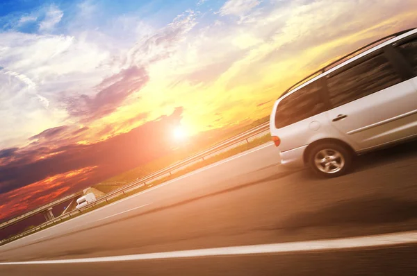 Srebrny Minivan Jadący Szybko Wiejskiej Asfaltowej Drodze Zachodem Słońca — Zdjęcie stockowe