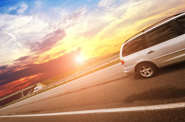 Srebrny Minivan Drodze Asfaltowej Wsi Przed Niebem Zachodem Słońca — Zdjęcie stockowe