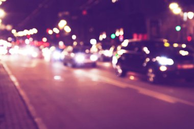 Karanlık gece sokak araba trafiğinin ve klasik filtresi olan ışıkların odaksız görüntüsü