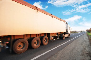 Kırsal yolda bulutlu mavi gökyüzüne karşı yazı yazmak için alanı olan büyük beyaz bir kamyon.