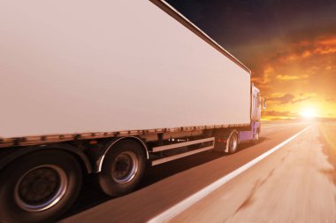 Parlak günbatımı ile gece gökyüzü karşı hareket halinde kırsal yolda metin için alanı olan büyük beyaz bir kamyon.