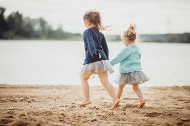 Göl kıyısında oynayan iki kız kardeş