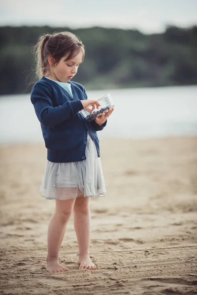 A menina comendo mirtilos de uma tigela de vidro — Fotografia de Stock