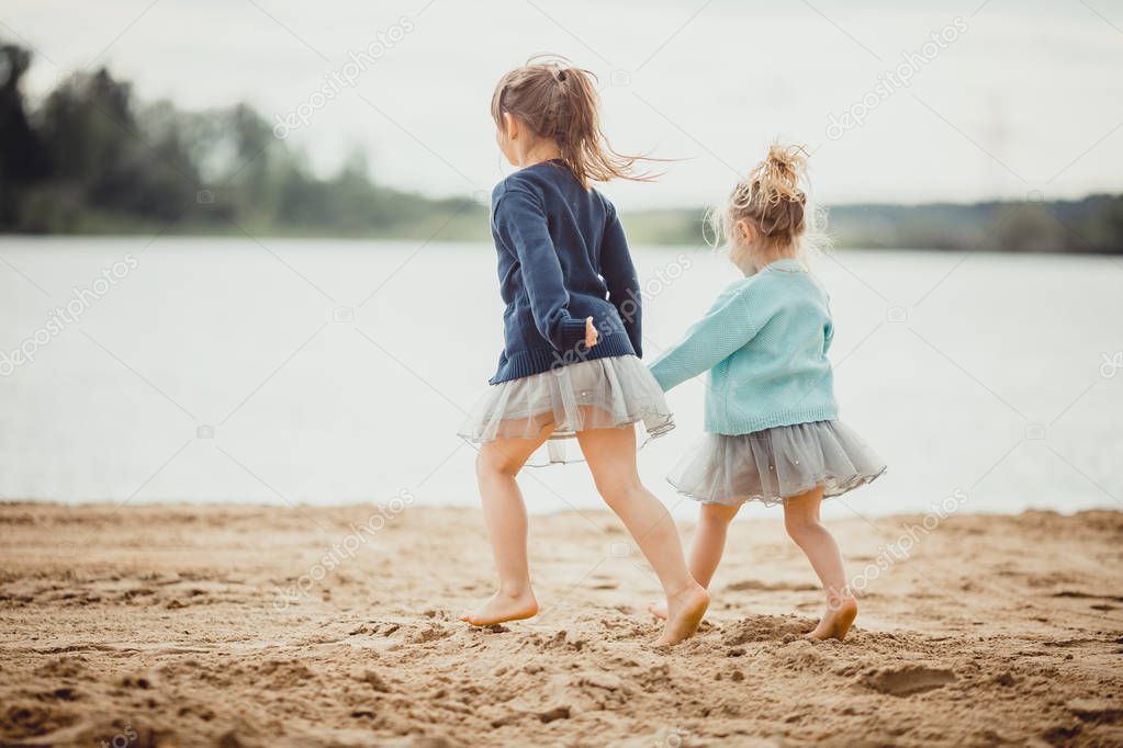Two sisters playing on the shore of the lake