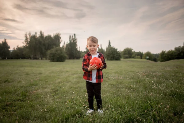 Un niño pequeño con un balón de fútbol con su perro — Foto de Stock