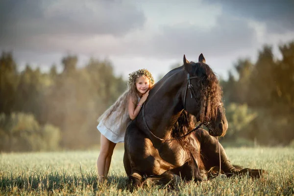 Bambina con stallone friesiano nero — Foto Stock