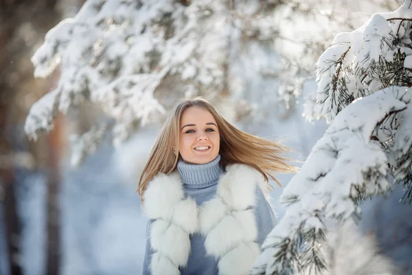 阳光明媚的冰冻天在雪林中美丽的年轻女子的户外肖像 — 图库照片