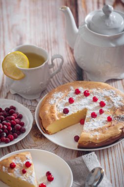 Kızılcık ve şekerli ahşap arka plan üzerinde Cheesecake