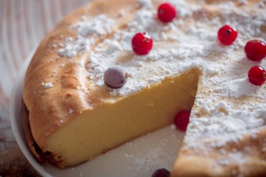 Kızılcık ve şekerli ahşap arka plan üzerinde Cheesecake
