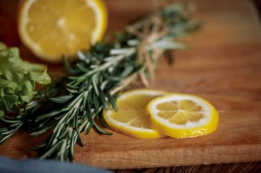 Karanlık burger tahıl ekmeği koyu seramik tabak, salata, biberiye ve limon ile 