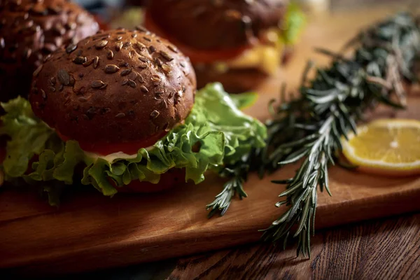 Dark Burger Pšenično Žitný Chléb Tmavá Keramická Deska Salát Rozmarýnem — Stock fotografie