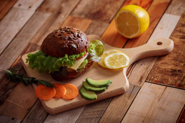 Dark Burger Pšenično Žitný Chléb Tmavá Keramická Deska Salát Rozmarýnem — Stock fotografie