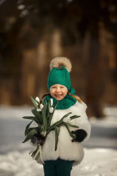 日当たりの良い春の日の白いチューリップの花束とかわいいの小さな少女の肖像画 — ストック写真