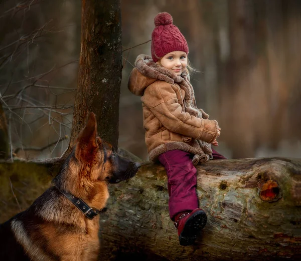 小女孩与德国牧羊人6个月小狗在早春森林 — 图库照片