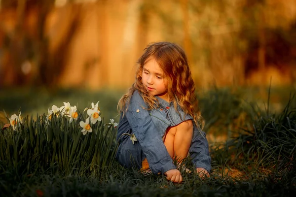 Little girl outdoor portrait near narcissus — Stock Photo, Image