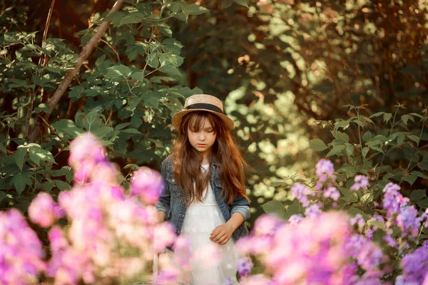 Liten flicka utomhus porträtt i en rosa blommor — Stockfoto