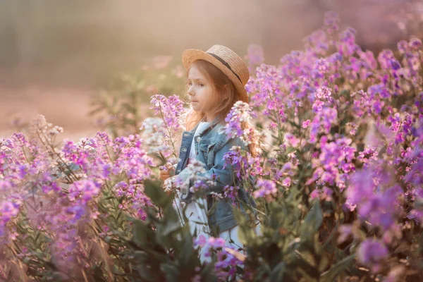 Malá holka z venkovního portrétu v růžových květech — Stock fotografie