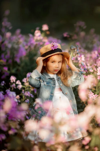 Liten flicka utomhus porträtt i en rosa blommor — Stockfoto