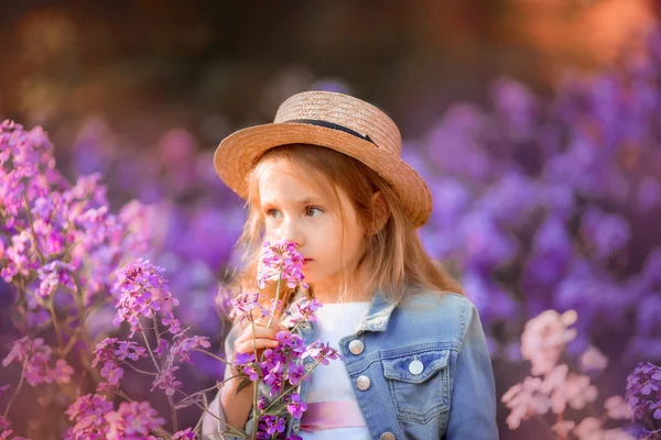 Liten flicka utomhus porträtt i en rosa blommor — Stockfoto