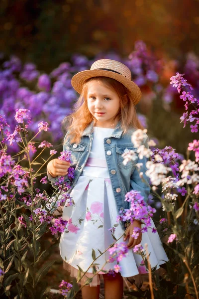 Mała dziewczynka na zewnątrz portret w różowe kwiaty — Zdjęcie stockowe