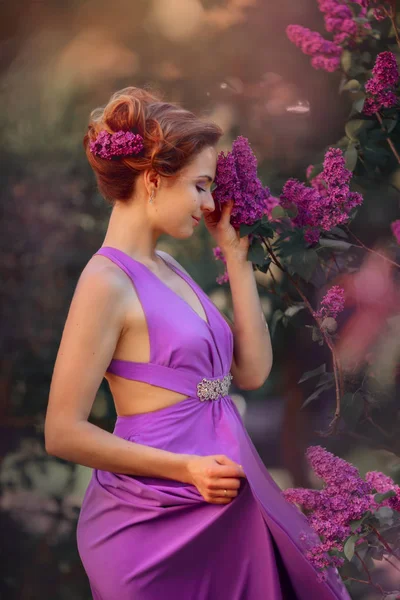 Hermosa mujer joven en un parque de flores — Foto de Stock