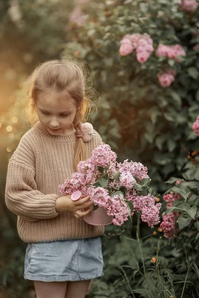 Uśmiechnięta Dziewczynka Bukietem Liliowych Kwiatów Wiosennym Ogrodzie — Zdjęcie stockowe