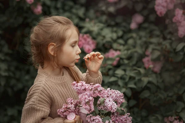 Усміхнена Маленька Дівчинка Букетом Бузкових Квітів Весняному Саду — стокове фото