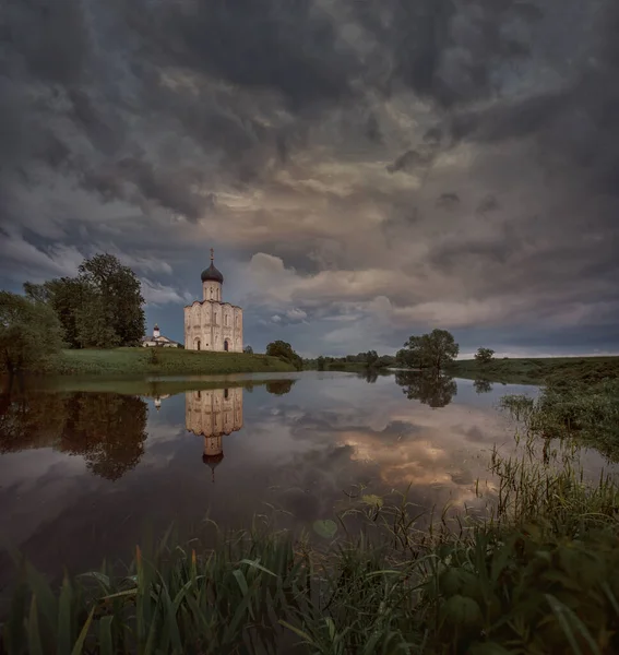Church of Intercession on the Nerlin the rainy spring evening. Russia. View from the lake — Stock Image Church Intercession Nerlin Rainy Spring Evening Russia View Lake Stock Photo