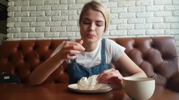 Молода жінка їсть мінливий торт — стокове відео