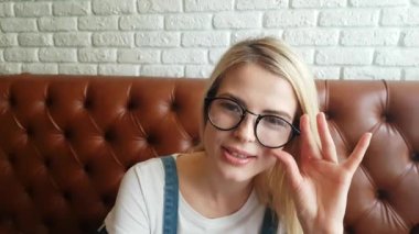 Deri kanepede oturan kız konuşuyor