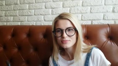 Deri kanepede oturan kız konuşuyor