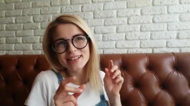 Deri kanepede oturan kız konuşuyor