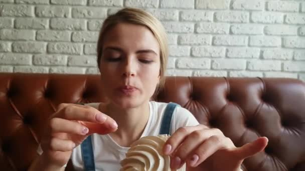 Ung kvinna äta merenge tårta — Stockvideo