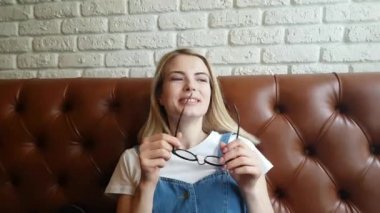 Deri kanepede oturan kız konuşuyor