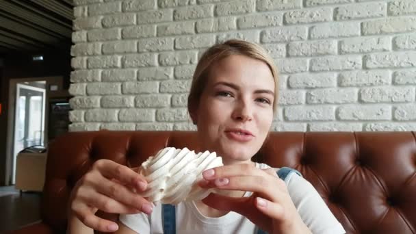 Mujer joven comiendo el pastel de merengue — Vídeos de Stock