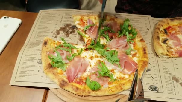 Femmina mano tagliare una fetta di pizza su un piatto — Video Stock