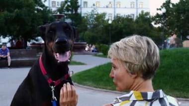 Yetişkin kadın ile onun büyük siyah doberman köpek