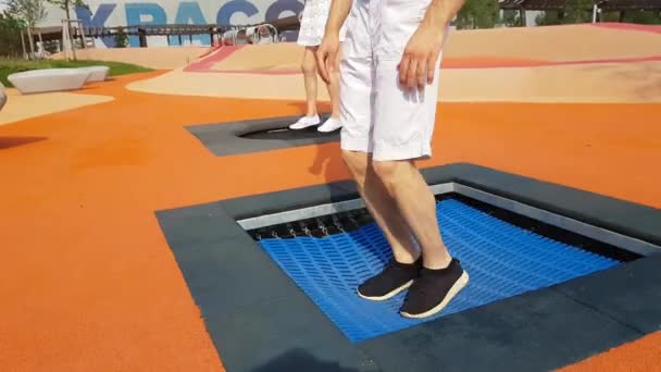 사람들이 다리 점프에서 작은 트램 폴 린 — 비디오