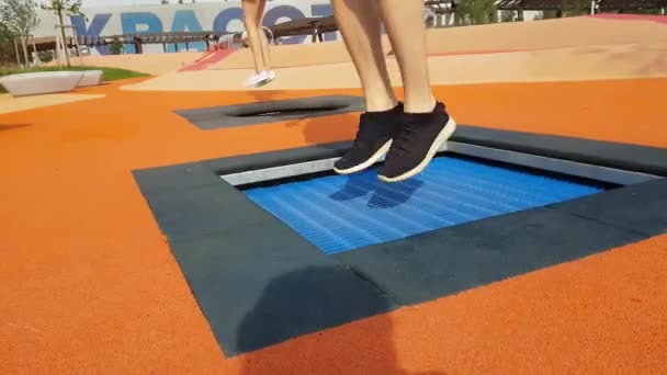 Les jambes des gens sautant sur un petit trampoline — Video
