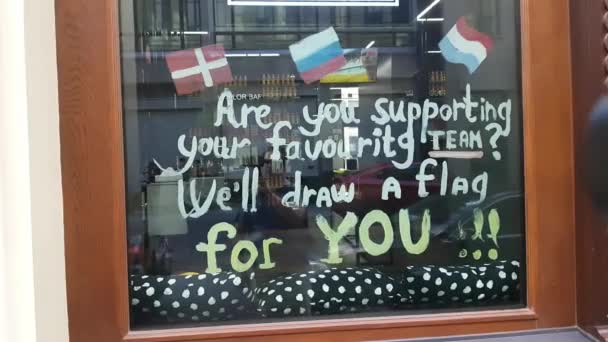 Schild am Café-Glas fordert die Fans auf, die Flagge ihres Landes zu hissen. — Stockvideo